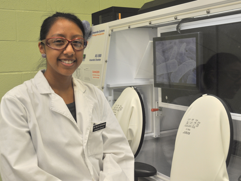Graduate student Belen Hernandez in a laboratory wearing a lab coat