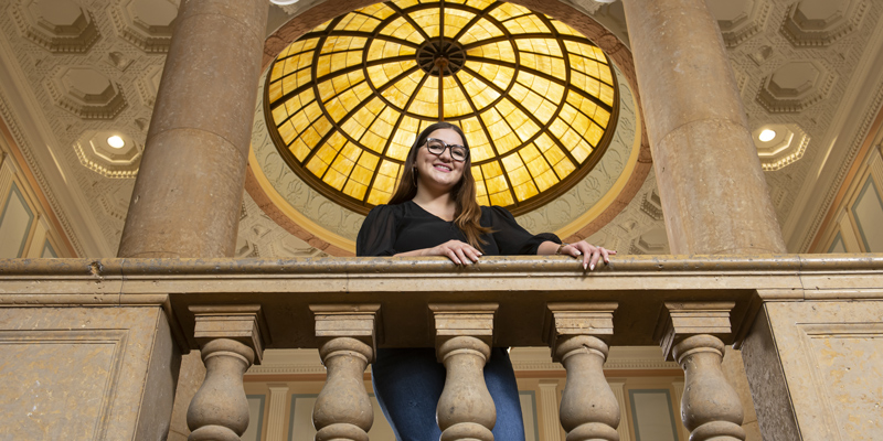 Natalia Rios Martinez looking down from a balcony in Beardshear Hall