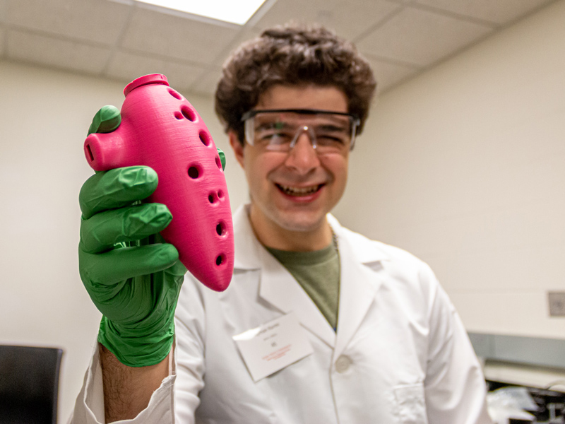 Ayman Karmi holds up a 3-D piece of pink plastic